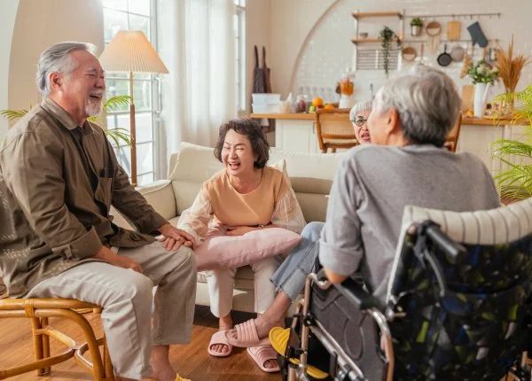 Seniors laughing together in a bright, sunlit living room