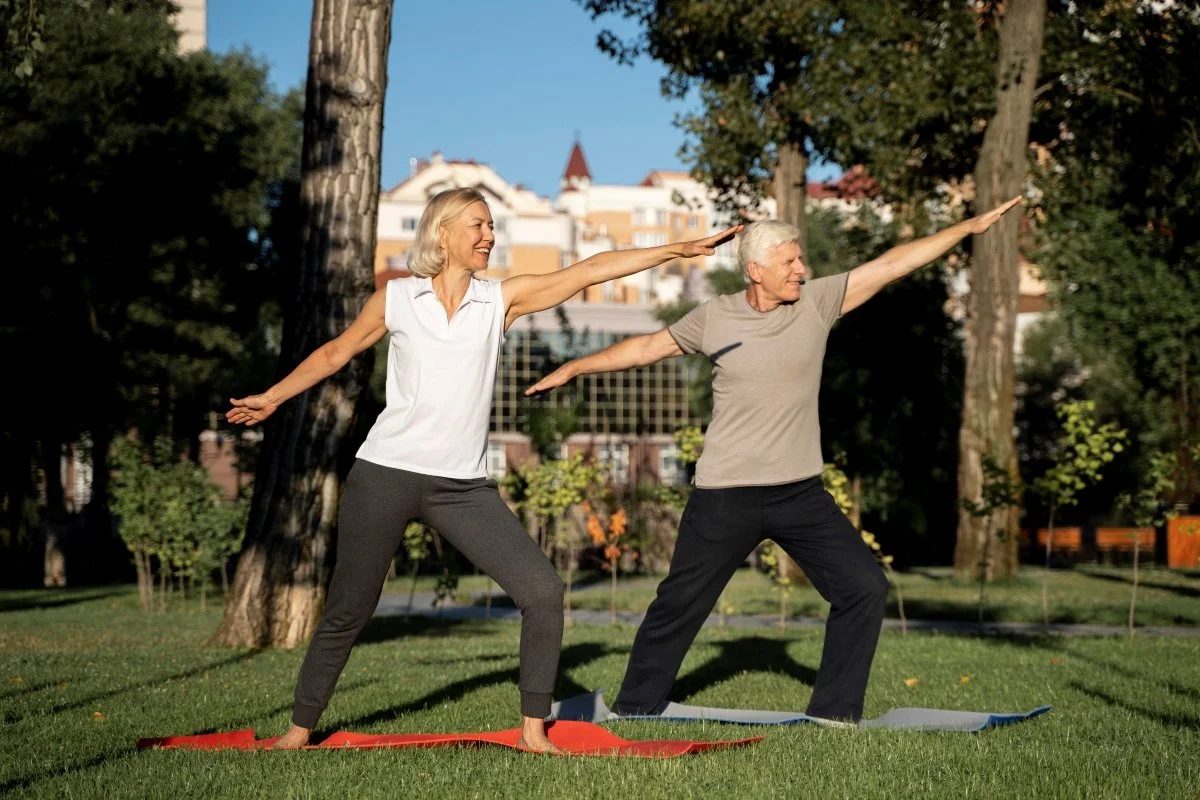 Active senior couple enjoying yoga outdoors